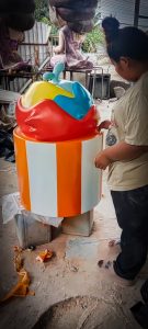 ชิ้นงานตกแต่งรูปคัพเค้กหลากสี ฐานลายแถบสีส้มสลับขาว